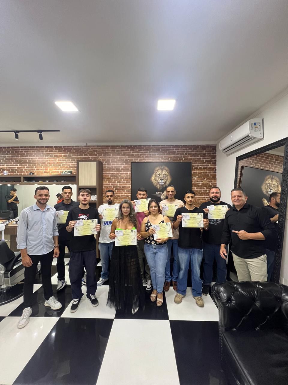 Barbeiros trabalhando em uma barbearia com ambiente escuro e moderno